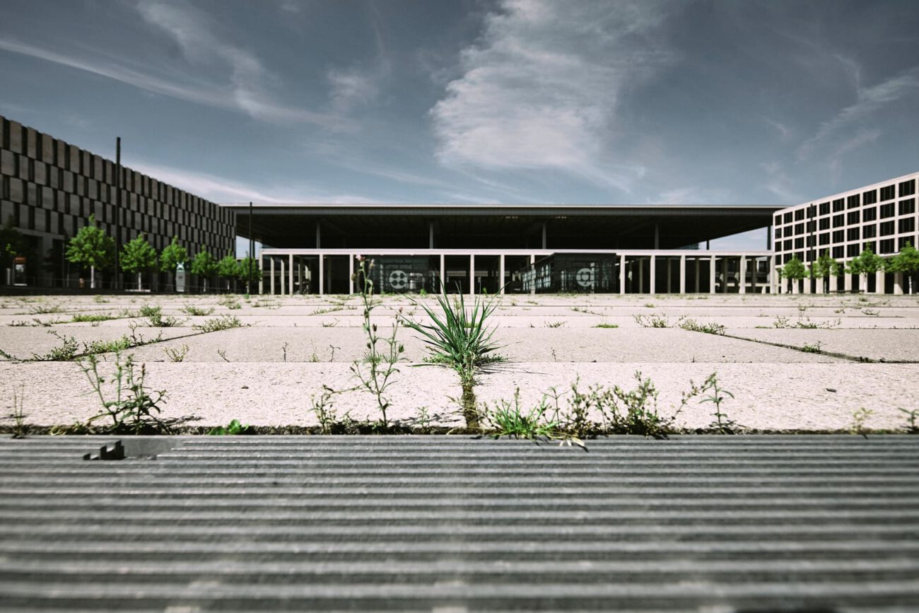 Leerplatz am BER Flughafen Berlin mit Flugstreifen am Himmel und Glasüberdachung, vor offizieller Eröffnung 2020